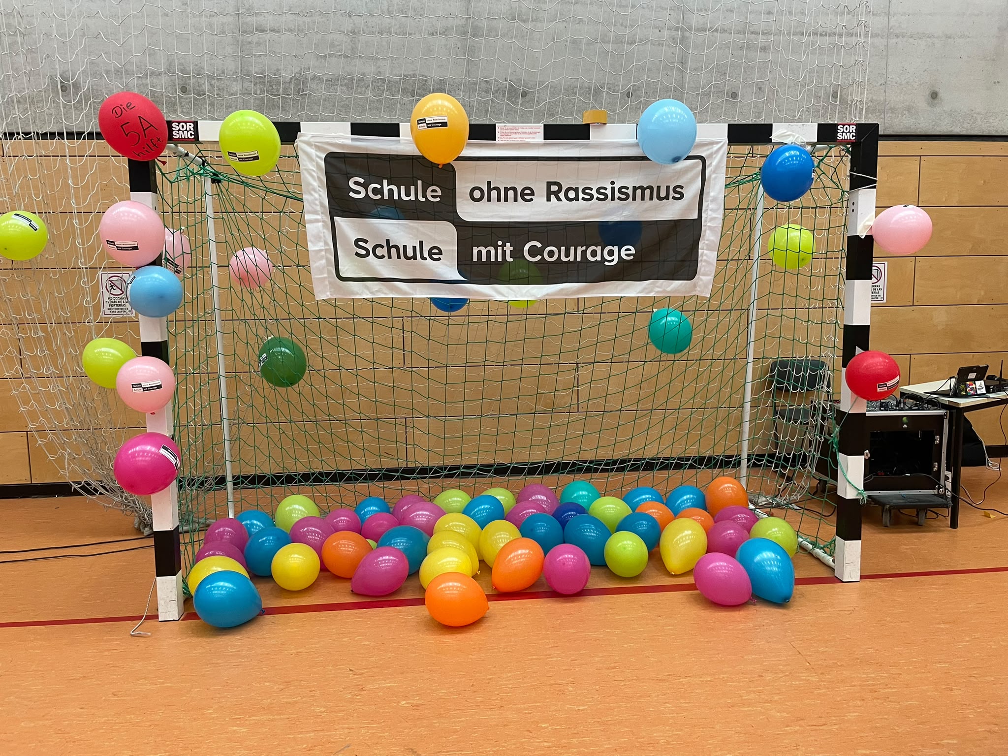 Banner „Schule ohne Rassismus – Schule mit Courage“ mit bunten Luftballons